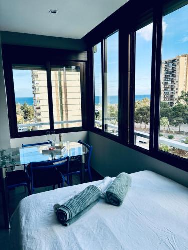 1 dormitorio con cama, mesa y ventanas en Apartamento en Aguadulce Playa con vistas al mar y piscina, en Aguadulce