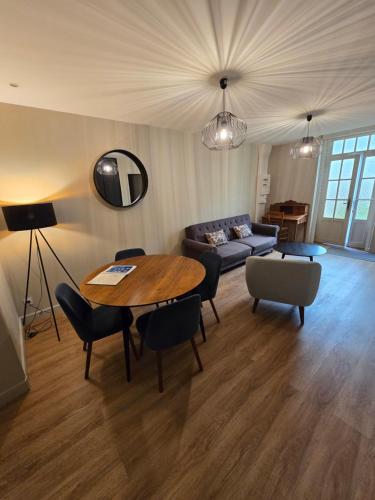 a living room with a table and a couch at Au Loup Historic Apartments in Bayeux