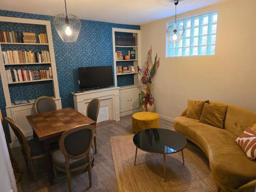 a living room with a couch and a table at Au Loup Historic Apartments in Bayeux