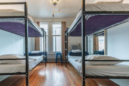 a room with three bunk beds in it at The Cambie Hostel Gastown in Vancouver