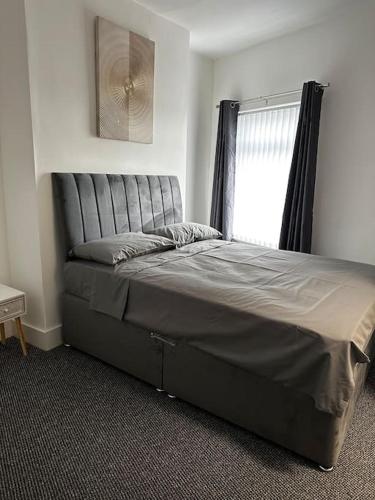 a large bed in a bedroom with a window at Kos apartment 3 in Walton on the Hill