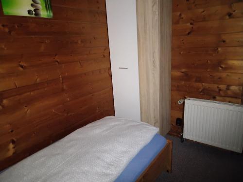 a bedroom with a bed with a wooden wall at FEWO Isla 2 in Elmenhorst