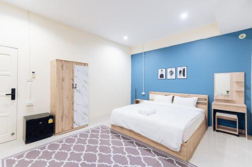 - une chambre avec un grand lit et un mur bleu dans l'établissement Hatyai Humble Home 03, à Hat Yai