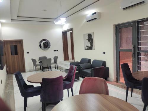 una sala d'attesa con tavoli e sedie di Passready Hotel and Suites Nnewi a Nnewi
