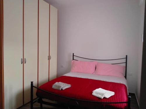 1 dormitorio con 1 cama con sábanas rojas y almohadas rosas en Villa Cecilia, en Scerni