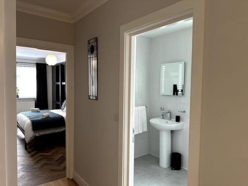 a bathroom with a sink and a bedroom with a bed at Seaview Penthouse in Seaham