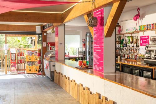 un bar avec un panneau rose sur le mur dans l'établissement Camping Saint-Nazaire, à Saint-Nazaire