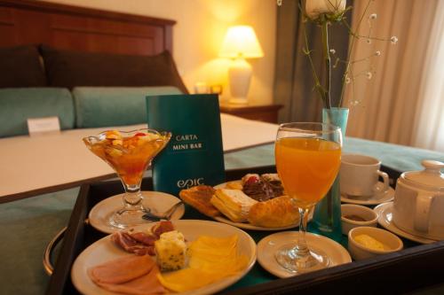 una bandeja de comida con dos vasos de zumo de naranja en Epic Hotel Villa Mercedes, en Villa Mercedes