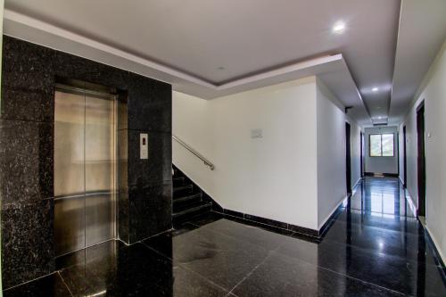 a hallway with black tile floors and a elevator at Super Collection O Ramachandra Residency in Kurmannapalem