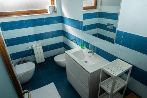 ein blau-weißes Bad mit einem Waschbecken und einem WC in der Unterkunft A.I.R. Sorrento Apartment 2 in Sorrent
