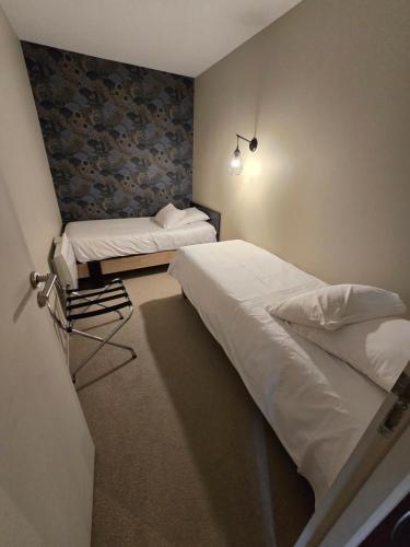 a bedroom with two twin beds in a room at Au Loup Historic Apartments in Bayeux