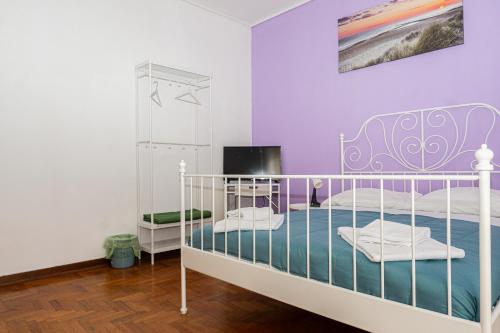 - une chambre avec un lit blanc et une télévision dans l'établissement A.I.R. Sorrento Apartment 2, à Sorrente