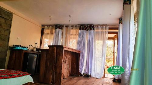 Bamasaba Community Lodge في Mbale: غرفة مع ستائر وغرفة مع نافذة
