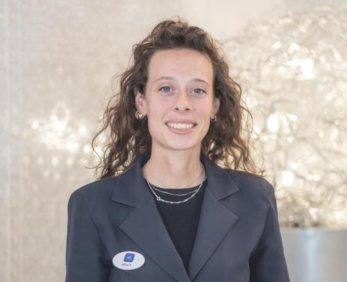 a woman in a suit is smiling at the camera at Hotel Fontana Verona in Verona
