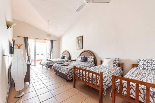 - un salon avec plusieurs lits et un canapé dans l'établissement Lugar encantador con piscina, Juan Dolio., à Juan Dolio