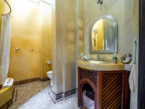 a bathroom with a sink and a toilet and a mirror at Dar Les Cigognes in Marrakech