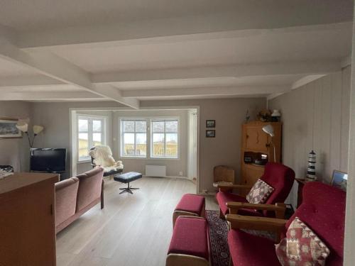 Sund的住宿－Sea-view house in Sund，客厅配有红色椅子和沙发