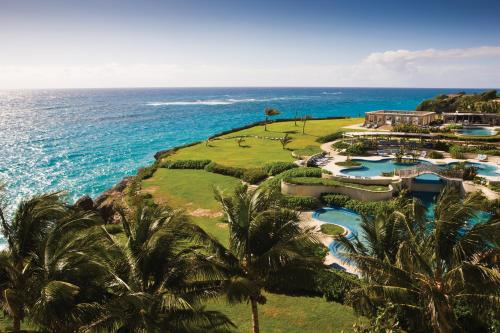 an aerial view of a resort with palm trees and the ocean at The Crane Resort in Saint Philip
