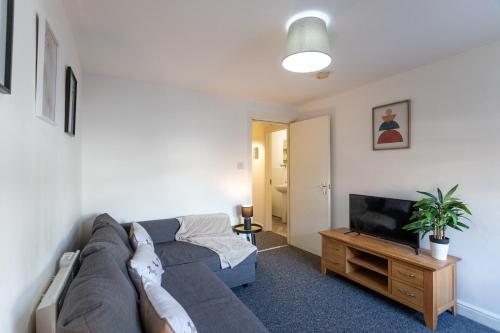a living room with a couch and a television at April Disc - Long Stay - Contractors in Bristol