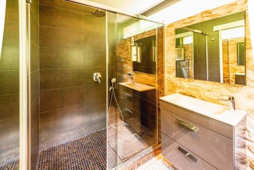 bagno con doccia, lavandino e specchio di Can Bet a Cala Llonga