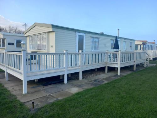 a mobile home with a porch and a deck at Lovely 8 Berth Caravan In Skegness With Free Wi-fi, Ref 96023d in Skegness