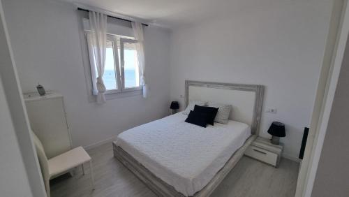 a white bedroom with a bed and two windows at Seaside Apartment Sleeps 6 with Balcony in Vilagarcia de Arousa