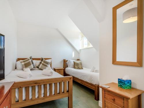 a bedroom with two beds and a mirror at Heatherdene in Goathland