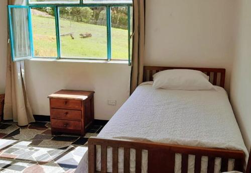 a bedroom with a bed and a window at Sauka Casa de campo in Villa de Leyva