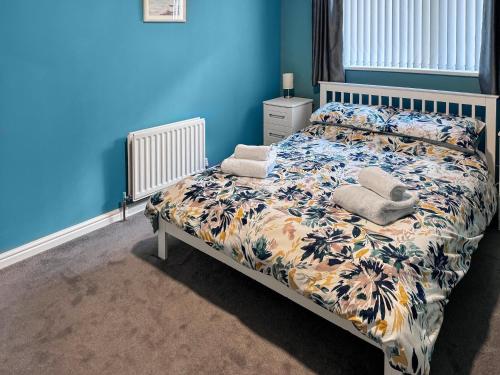 een slaapkamer met een bed met een blauwe muur bij Ritson Wharf in Maryport