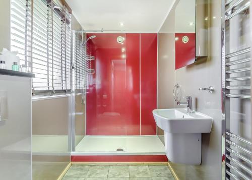 a bathroom with a red shower and a sink at Wildside Highland Lodges in Whitebridge