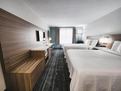 una camera d'albergo con due letti e una televisione di Americas Best Value Inn & Suites-Foley a Foley