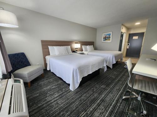 a hotel room with two beds and a chair at Americas Best Value Inn & Suites-Foley in Foley