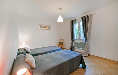 a bedroom with a large bed and a window at Nice Home In Bordezac With Outdoor Swimming Pool in Bordezac