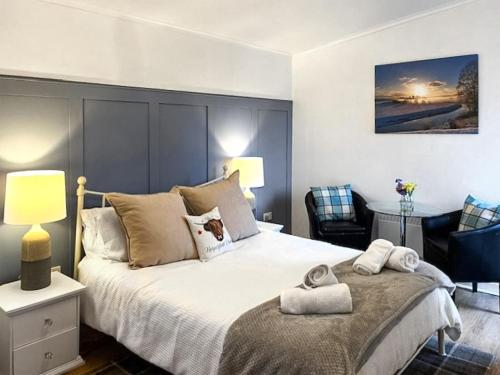 a bedroom with a large bed and a desk at Harperfield Chalet in Lanark