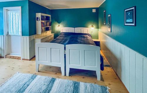 a bedroom with a white bed in a blue wall at Stunning Home In Svingvoll With House A Mountain View in Svingvoll