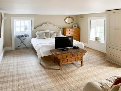 a bedroom with a bed and a table with a laptop on it at Bradley Hall in Stanton in Peak