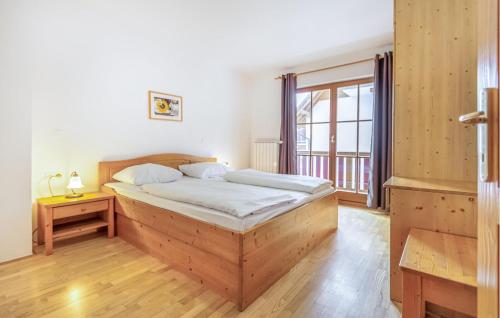 a bedroom with a wooden bed and a window at Lovely Apartment In Pohorje With Indoor Swimming Pool in Hočko Pohorje