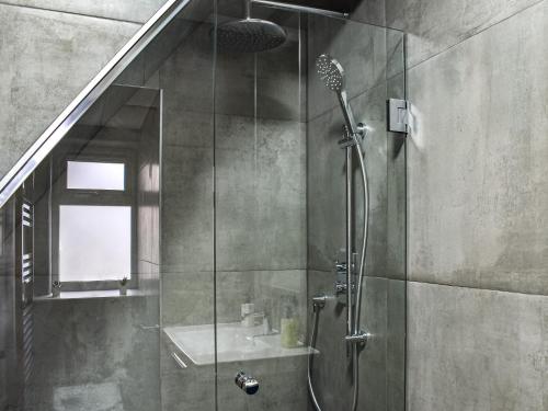 een badkamer met een douche en een glazen deur bij Bramble Cottage in Bramham