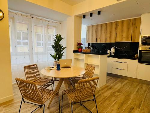 a kitchen with a table and chairs with a laptop on it at Annamaria B&B Alicante Centro in Alicante