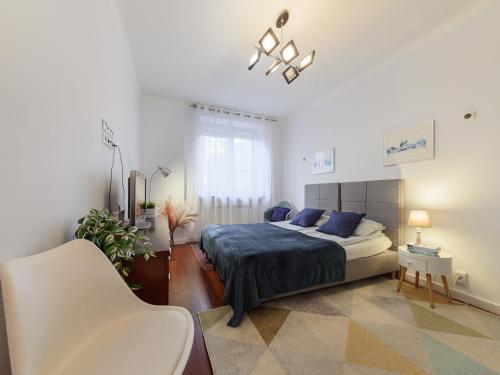 a bedroom with a bed with blue pillows at Bonifraterska Papaya Apartment in Warsaw