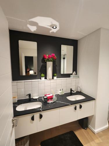 uma casa de banho com dois lavatórios e dois espelhos em NINE PALMS na Cidade do Cabo