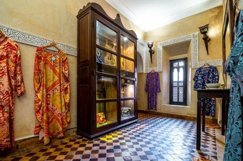 a room with a large wooden cabinet with glass doors at Dar Les Cigognes in Marrakech