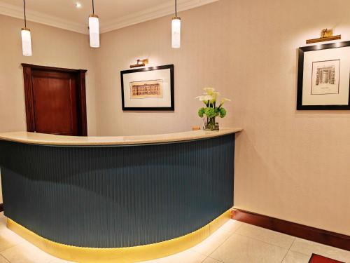 a lobby with a counter with flowers on the wall at Frederick House Hotel in Edinburgh