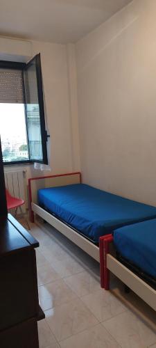 1 dormitorio con 2 camas y ventana en Appartamento Gianna en Alghero
