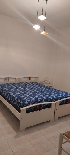 Cama en habitación blanca con colchón azul en Appartamento Gianna en Alghero