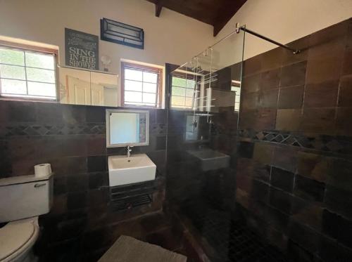 a bathroom with a toilet and a sink and a shower at Beefwood Beach House in Pennington