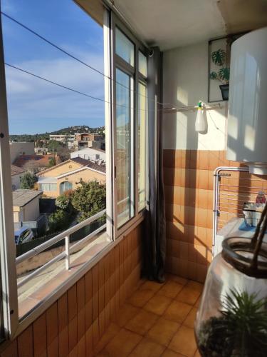 a room with a window with a view of a city at Appartement chez Eline in Les Angles Gard