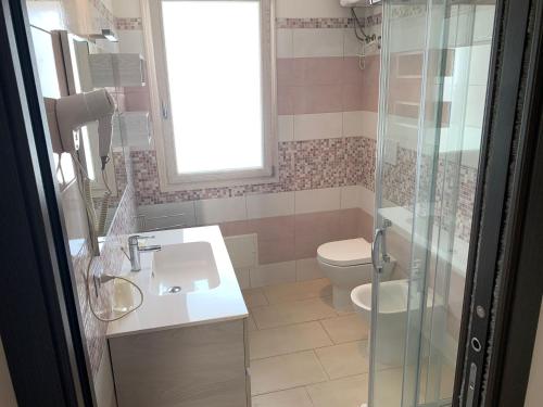 ein Bad mit einem WC, einem Waschbecken und einer Dusche in der Unterkunft Cala Bianca app 1 in SantʼAntìoco