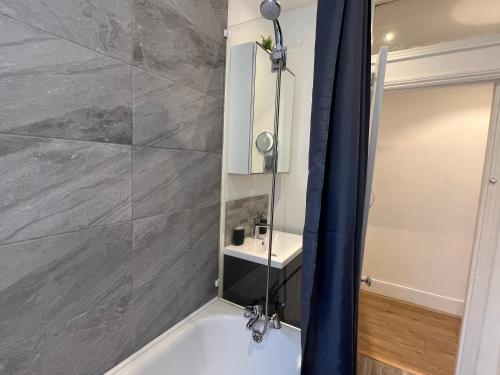 a bathroom with a shower with a tub and a sink at 2 Bedroom flat 10 min walk to tube in London