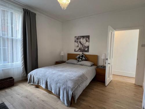 a bedroom with a bed and a chandelier at 2 Bedroom flat 10 min walk to tube in London